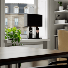 Stand By Me 50cm Noir lampe de table De By Rydéns - Le large abat-jour en tissu noir contraste avec les colonnes plus &eacute;troites de la base de la lampe, toutes deux d&eacute;cor&eacute;es d&#39;un symbole en m&eacute;tal, un signe de paix d&#39;un c&ocirc;t&eacute; et un c&oelig;ur de l&#39;autre.