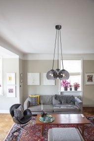 Salle Ø45 Couleur fumée suspension De Cottex - La lampe se compose de trois sphères en verre de couleur fumée, dont l'une est suspendue à un plafonnier noir, créant une atmosphère élégante et industrielle.