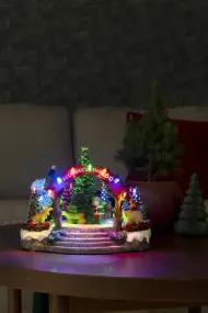 Décoration De Noël Mécanique Avec Zoo 20cm Multicolore De Konstsmide - Cette d&eacute;coration de No&euml;l m&eacute;canique pr&eacute;sente une sc&egrave;ne color&eacute;e avec 19 lumi&egrave;res LED blanches chaudes, de la musique, des animaux et le P&egrave;re No&euml;l autour d'un sapin de No&euml;l &eacute;tincelant.