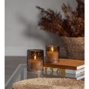 LED Bougie Flamme Leaf Brun De Star Trading - Flamme Leaf est une lanterne en verre à piles en verre brun avec un motif de feuille en relief autour d'une bougie en cire blanche.