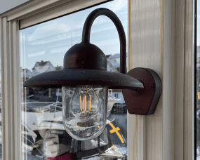 Nisse Cuivre oxydé lampe d’extérieur De Westal - Son abat-jour en verre transparent assure une diffusion optimale de la lumière et crée une ambiance chaleureuse aux entrées, sur les façades ou les terrasses.