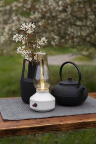 Lampe de table rechargeable 25cm Blanc portable De Konstsmide - Fabriquée en métal et en verre, elle est dotée d'un socle blanc et d'un variateur pratique permettant de régler facilement l'intensité de sa lumière blanche chaude et tamisée.