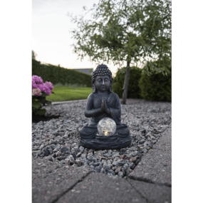 Buddha Gris lampe solaire De Star Trading - La sph&egrave;re transparente sur le devant diffuse une douce lumi&egrave;re blanche chaude au cr&eacute;puscule, cr&eacute;ant une atmosph&egrave;re harmonieuse.