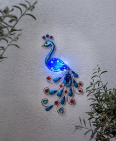 Peacock Polyvalent lampe solaire De Star Trading - À la tombée de la nuit, elle diffuse une douce lumière blanche qui met en valeur ses détails décoratifs.