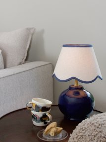 Nell 34cm Bleu lampe de table De PR Home - Son pied sph&eacute;rique bleu profond et brillant s'harmonise parfaitement avec l'abat-jour en tissu beige, cr&eacute;ant un ensemble doux et harmonieux, id&eacute;al pour les chambres et les salons.