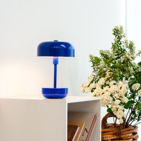 Haipot 25cm Bleu portable De Dyberg Larsen - La conception ouverte de l'abat-jour assure une belle réflexion de la lumière qui met en valeur la couleur de la base, et lorsque l'obscurité tombe, la lampe crée un jeu de lumière atmosphérique.