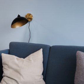 Futura 43cm Laiton applique murale De Dyberg Larsen - Il est fabriqué en métal avec un extérieur noir et un intérieur en laiton, ce qui lui donne un aspect élégant.