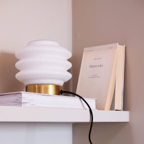 Diva 15cm Laiton lampe de table De Dyberg Larsen - Den elegant designade Diva bordslampan i m&auml;ssing ger en sofistikerad touch till varje hem och &auml;r ett konstverk som tillf&ouml;r liv och sk&ouml;nhet till rummet.