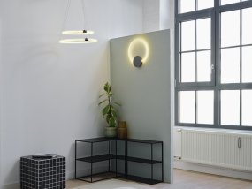 Aura Ø37 Noir De Ledvance - Lampan har tv&aring; olika belysningspunkter med integrerad LED, en bakom v&auml;ggplattan och cirkeln.