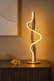 Lambada 60cm Champagne De Lucide - Lambada est une &eacute;l&eacute;gante lampe de table en m&eacute;tal, dot&eacute;e d'une finition champagne exclusive et d'une forme douce et organique qui attire imm&eacute;diatement le regard.