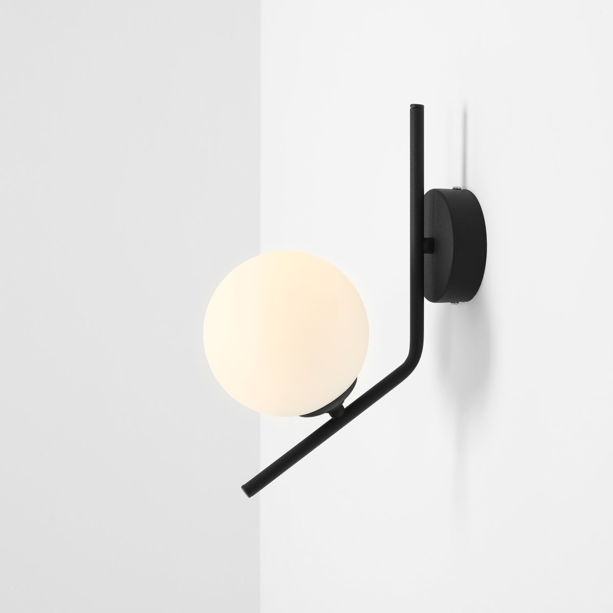 Gallia Ø14 Noir applique murale De Artera - Avec un cadre noir et un globe opale rond, la lampe fournit une lumi&egrave;re douce et diffuse qui cr&eacute;e une atmosph&egrave;re chaleureuse et accueillante dans la pi&egrave;ce.