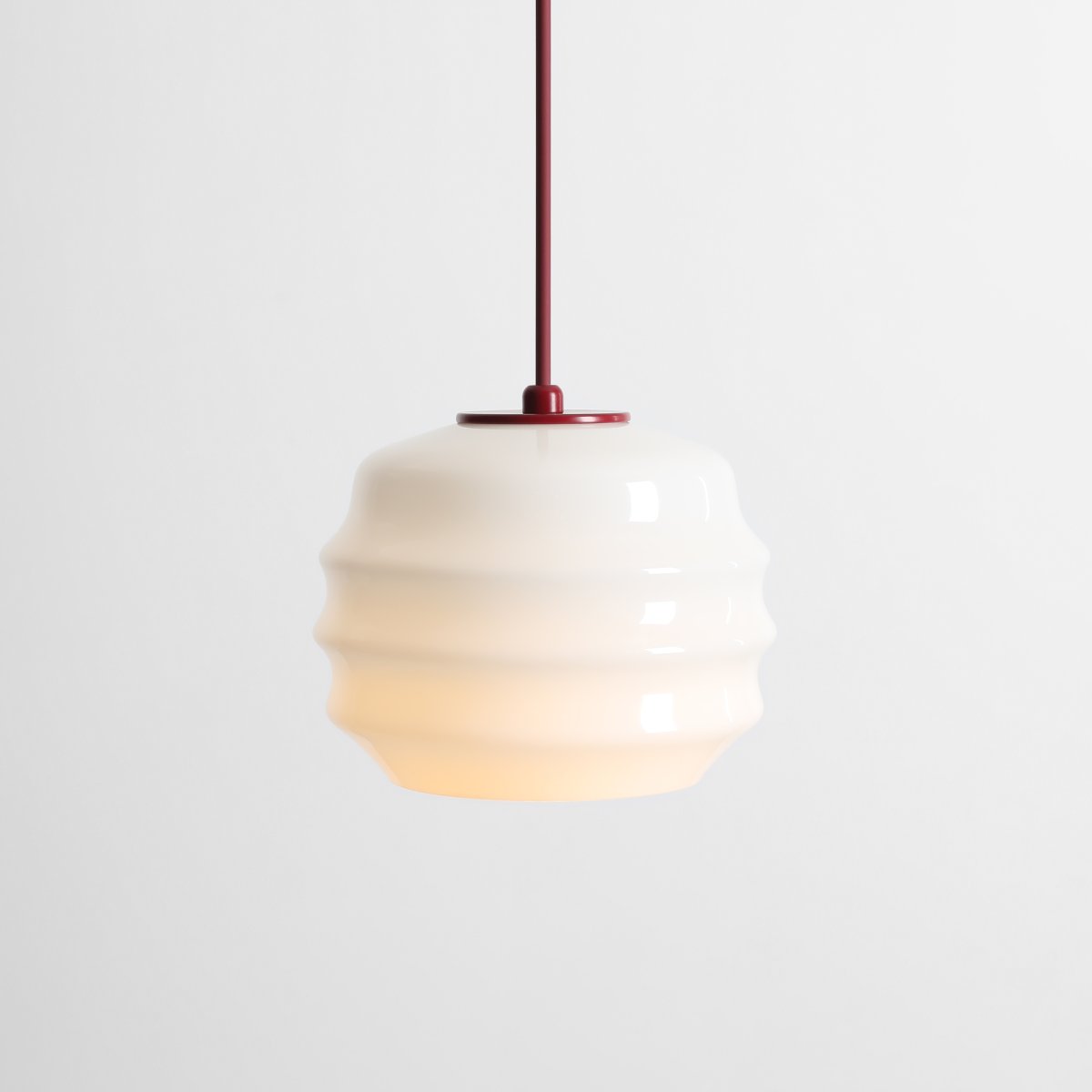 Puff Ø16 Bourgogne suspension De Artera - Son abat-jour décoratif en verre opale blanc séduit par sa forme incurvée, conférant à la lampe une allure à la fois ludique et raffinée.