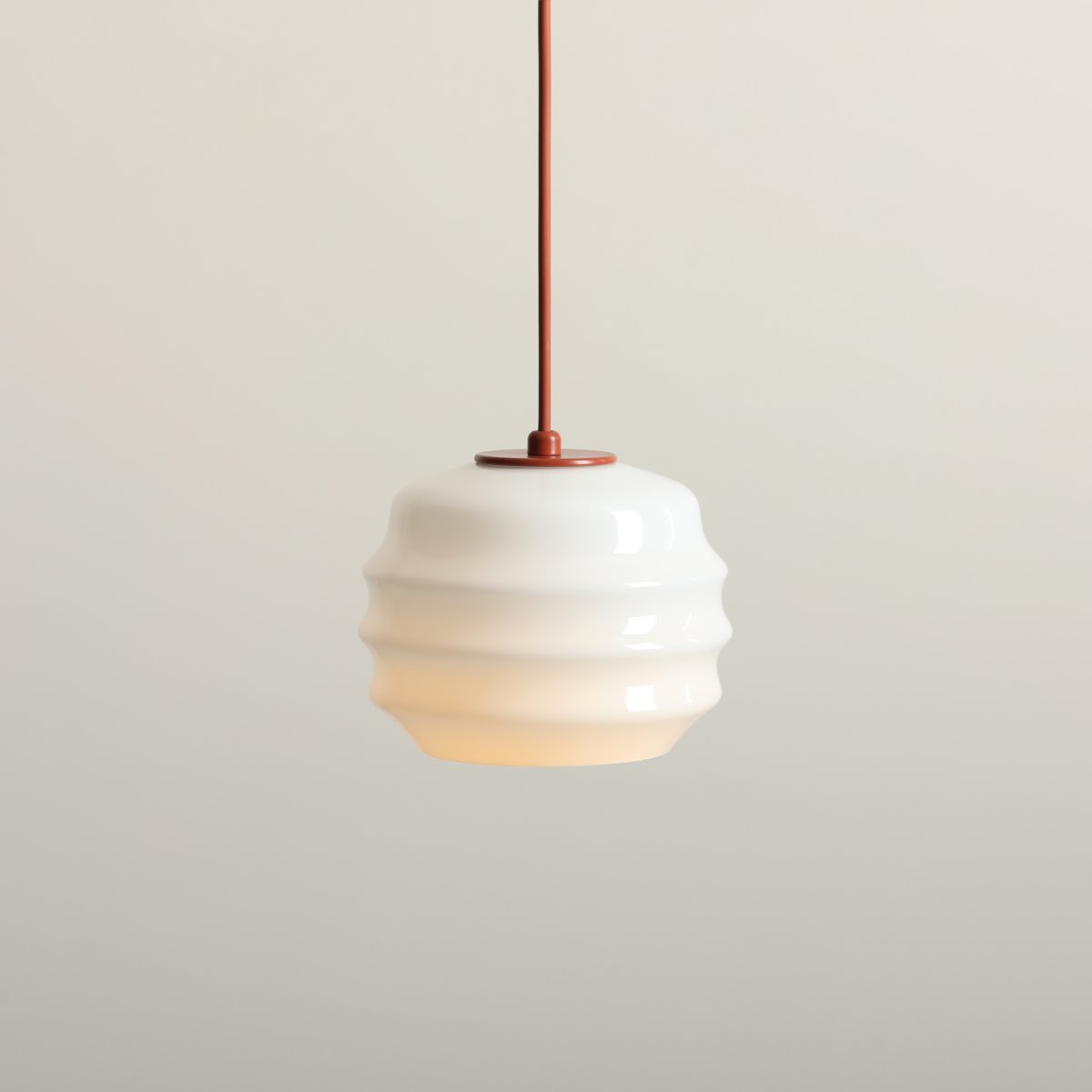Puff Ø16 Terre cuite suspension De Artera - Son abat-jour décoratif en verre opale blanc séduit par sa forme incurvée, conférant à la lampe une allure à la fois ludique et raffinée.