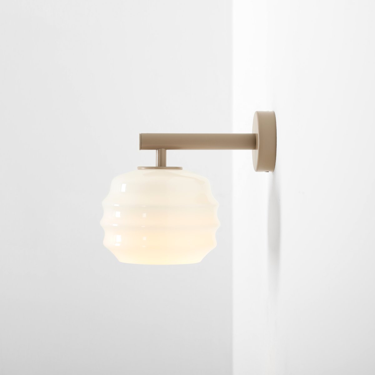Puff 23cm Beige applique murale De Artera - Son abat-jour décoratif en verre opale blanc séduit par sa forme incurvée, conférant à la lampe une allure à la fois ludique et raffinée.