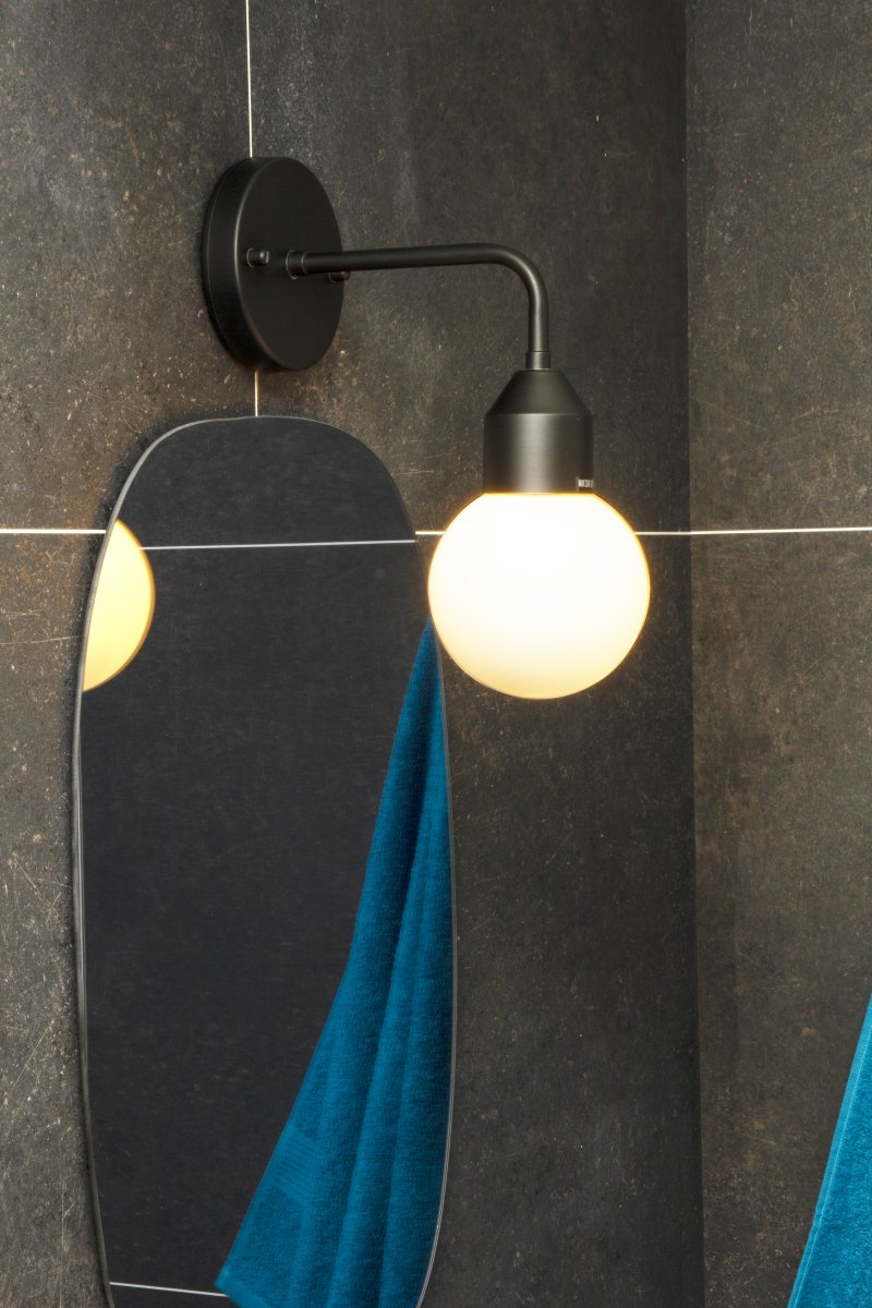 Florens Ø12 Noir lampe de salle de bain De Aneta Lighting - Florens est une élégante applique de salle de bain en métal laqué noir, surmontée d'un dôme rond en verre opale blanc diffusant une lumière douce et agréable.