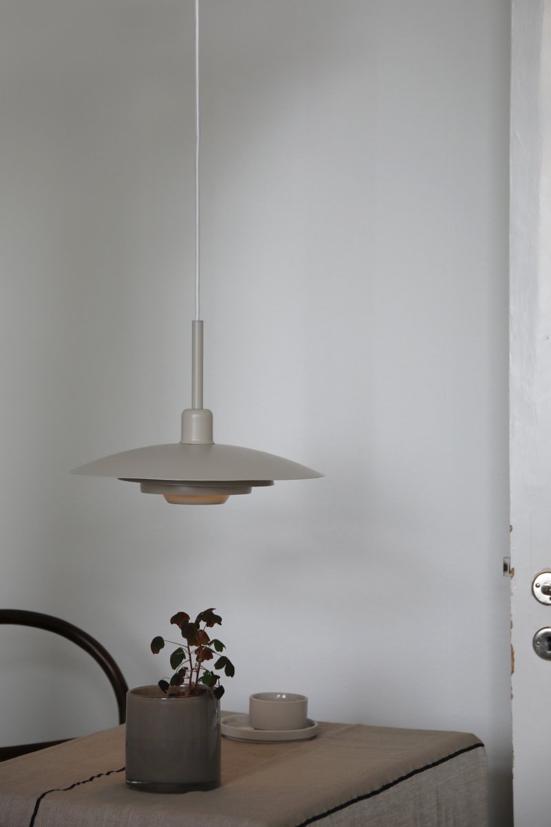 Piny Ø35 Beige suspension De Markslöjd - Son style rappelle celui des anciens luminaires d'ascenseur, mais avec une touche beaucoup plus élégante.