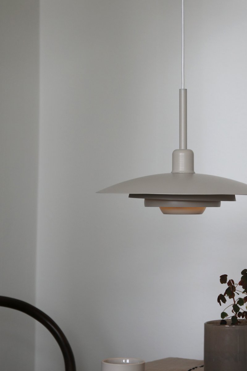 Piny Ø35 Beige suspension De Markslöjd - Son style rappelle celui des anciens luminaires d'ascenseur, mais avec une touche beaucoup plus élégante.