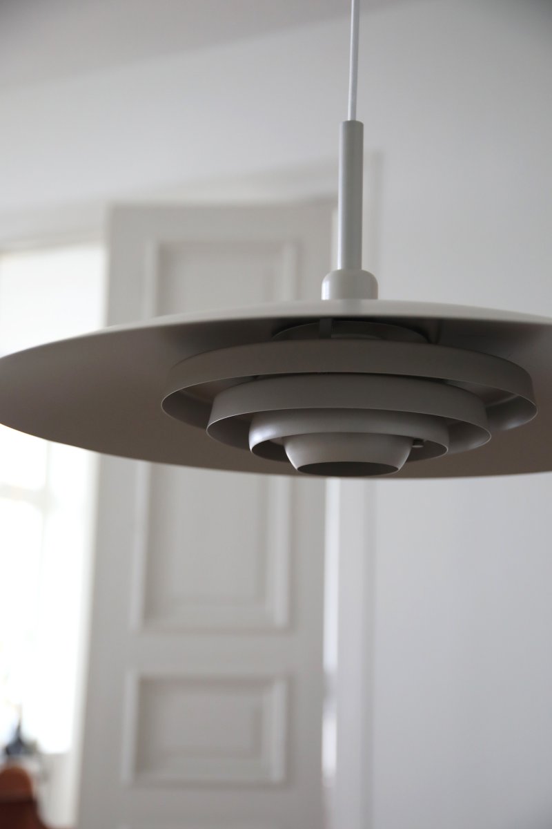 Piny Ø57 Beige suspension De Markslöjd - Son style rappelle celui des anciens luminaires d'ascenseur, mais avec une touche beaucoup plus élégante.