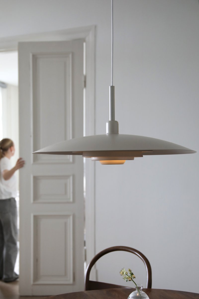 Piny Ø57 Beige suspension De Markslöjd - Son style rappelle celui des anciens luminaires d'ascenseur, mais avec une touche beaucoup plus élégante.