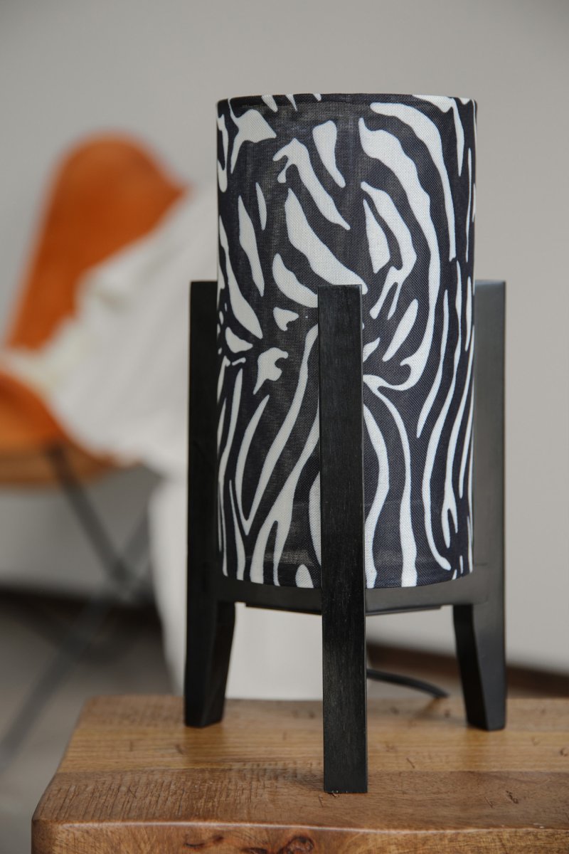Eruca 34cm Zèbre lampe de table De Markslöjd - Son pied en bois noir s'harmonise parfaitement avec son abat-jour cylindrique en tissu &agrave; motif z&egrave;bre noir et blanc, conf&eacute;rant &agrave; la lampe un caract&egrave;re graphique et expressif.