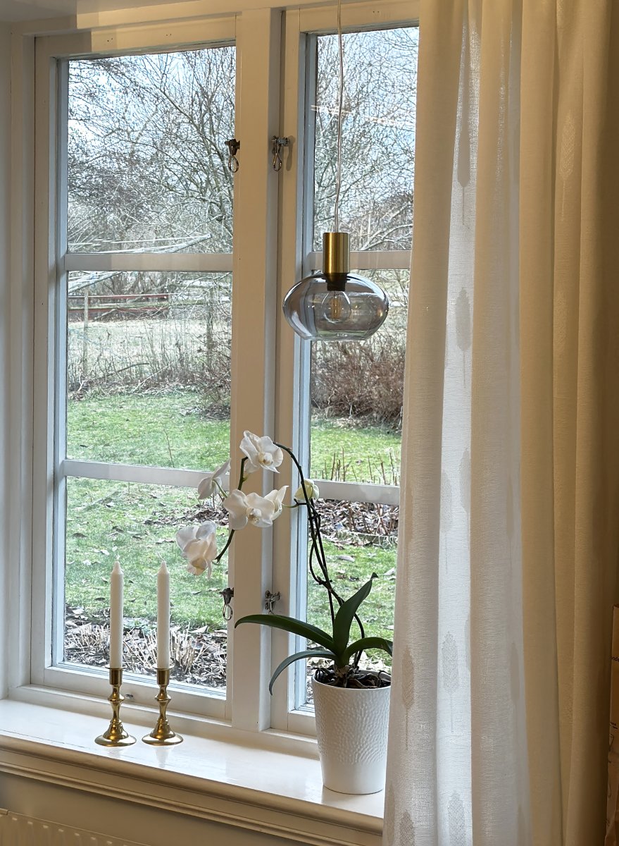 Bell Ø15 Couleur fumée lampe de fenêtre De Aneta Lighting - Fabriquée en laiton mat avec un dôme rond en verre fumé, elle diffuse une lumière douce et agréable.