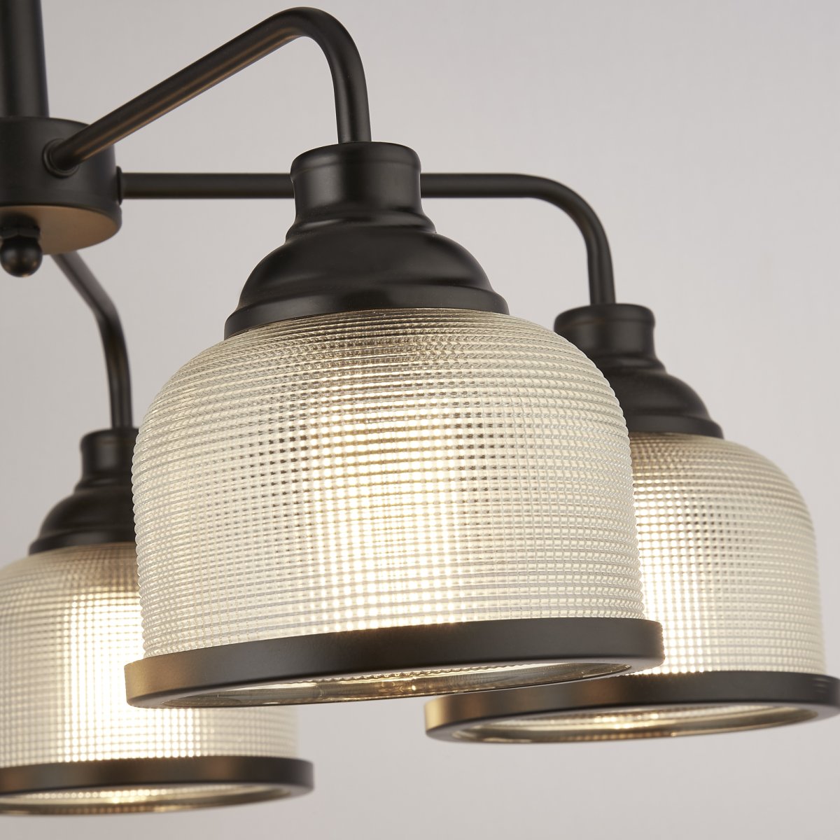 Highworth Ø58 Noir suspension De Searchlight - Ses cinq abat-jour en verre dépoli et côtelé, façon holophane, diffusent une lumière douce et agréable, créant un jeu d'ombres et de lumières captivant.