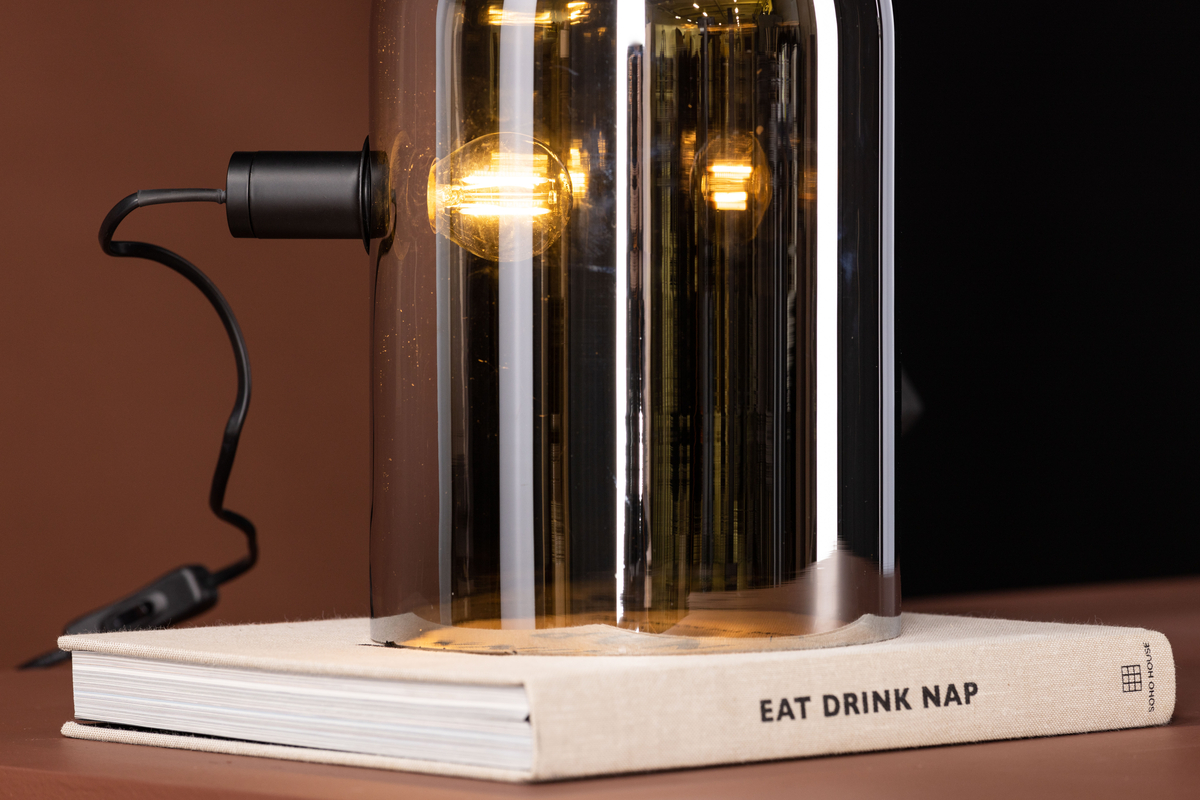 Quentin 32cm Couleur fumée lampe de table De Venture Design - Ses formes arrondies et son verre fum&eacute; effet miroir en font une lampe tendance qui s'harmonise facilement avec d'autres meubles et son format compact lui permet de trouver sa place m&ecirc;me dans les espaces restreints, comme sur une &eacute;tag&egrave;re.