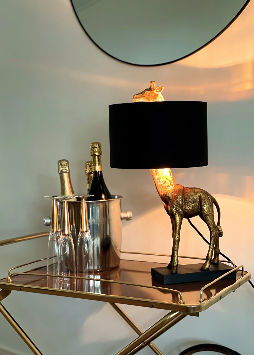 Affe 50cm Or lampe de table De Aneta Lighting - Lampe de table singe avec pied de lampe en m&eacute;tal laqu&eacute; noir et une girafe d&eacute;corative de couleur dor&eacute;e dont la t&ecirc;te d&eacute;passe de l'abat-jour en textile.