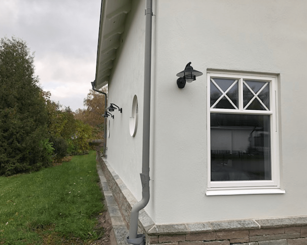 Tellus Noir lampe d’extérieur De Westal - L'applique murale Tellus Ned est une lampe de fabrication su&eacute;doise avec une douille E27 et un abat-jour en verre blanc qui entoure la source lumineuse et fournit une lumi&egrave;re diffuse.