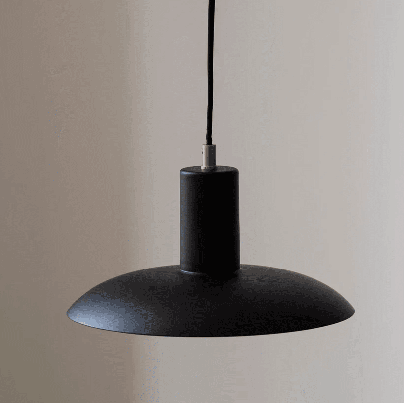 Vega Ø25 Noir suspension De H. Skjalm P - La suspension Vega est une lampe élégante en métal noir mat avec des détails en laiton qui émet une lumière large et douce, créant une atmosphère chaleureuse et accueillante.