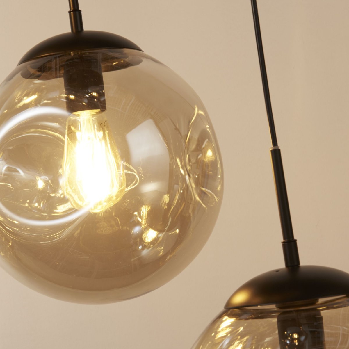 Punch Ø60 Champagne suspension De Searchlight - La forme légèrement concave des abat-jour, associée à la structure en métal noir, offre un contraste moderne et élégant qui s'harmonise avec différents styles de décoration intérieure.