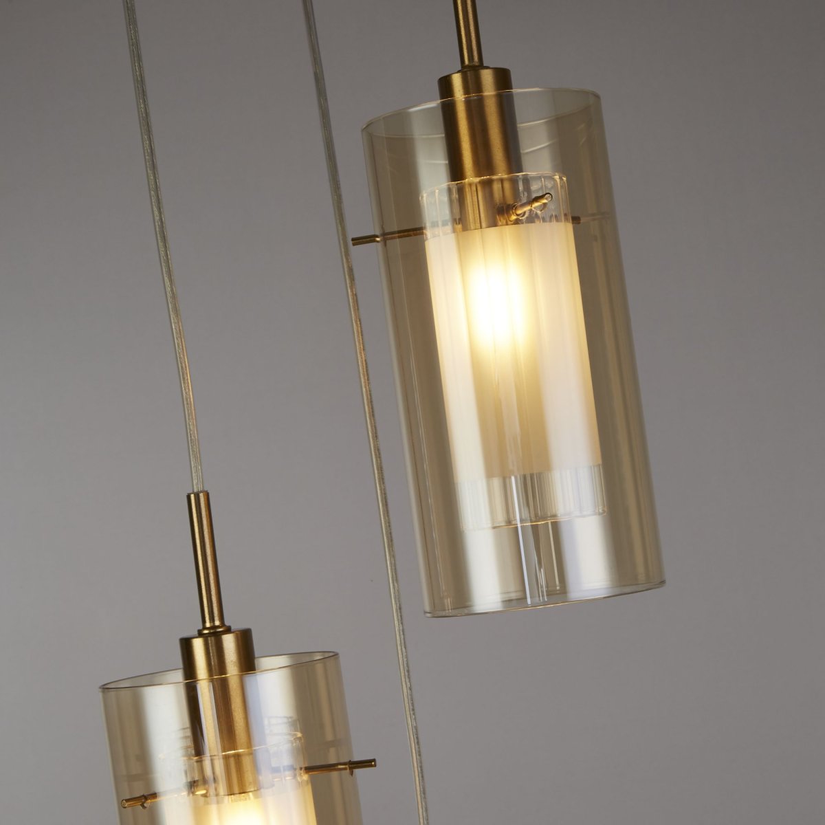 Duo Ø26 Bronze suspension De Searchlight - Fabriqu&eacute;e en m&eacute;tal avec une &eacute;l&eacute;gante finition bronze, elle se compose de trois abat-jour cylindriques en verre ambr&eacute;.