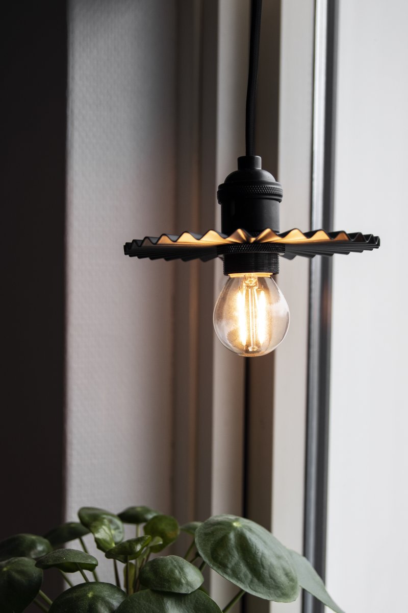 Omega Ø15 Noir lampe de fenêtre De Globen Lighting - Elle peut également être placée horizontalement sur une étagère ou une commode pour apporter une touche décorative.