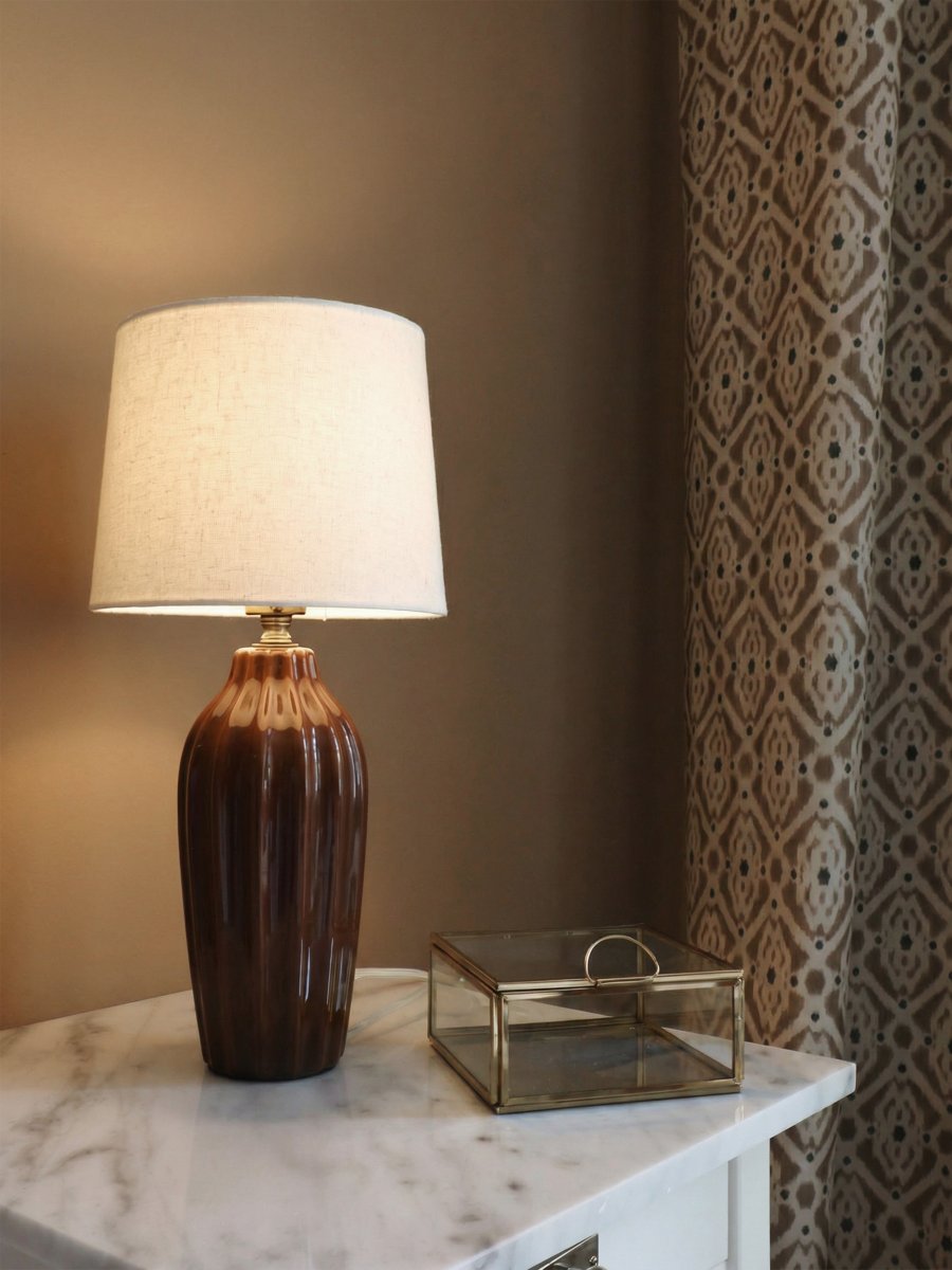 Lyon 40cm Brun lampe de table De PR Home - Gr&acirc;ce &agrave; son design styl&eacute; et accueillant, Lyon trouve sa place aussi bien sur une table d'appoint, une table de chevet ou pr&egrave;s d'une fen&ecirc;tre, o&ugrave; elle devient un &eacute;l&eacute;ment d&eacute;coratif et une source d'ambiance dans les int&eacute;rieurs classiques comme modernes.