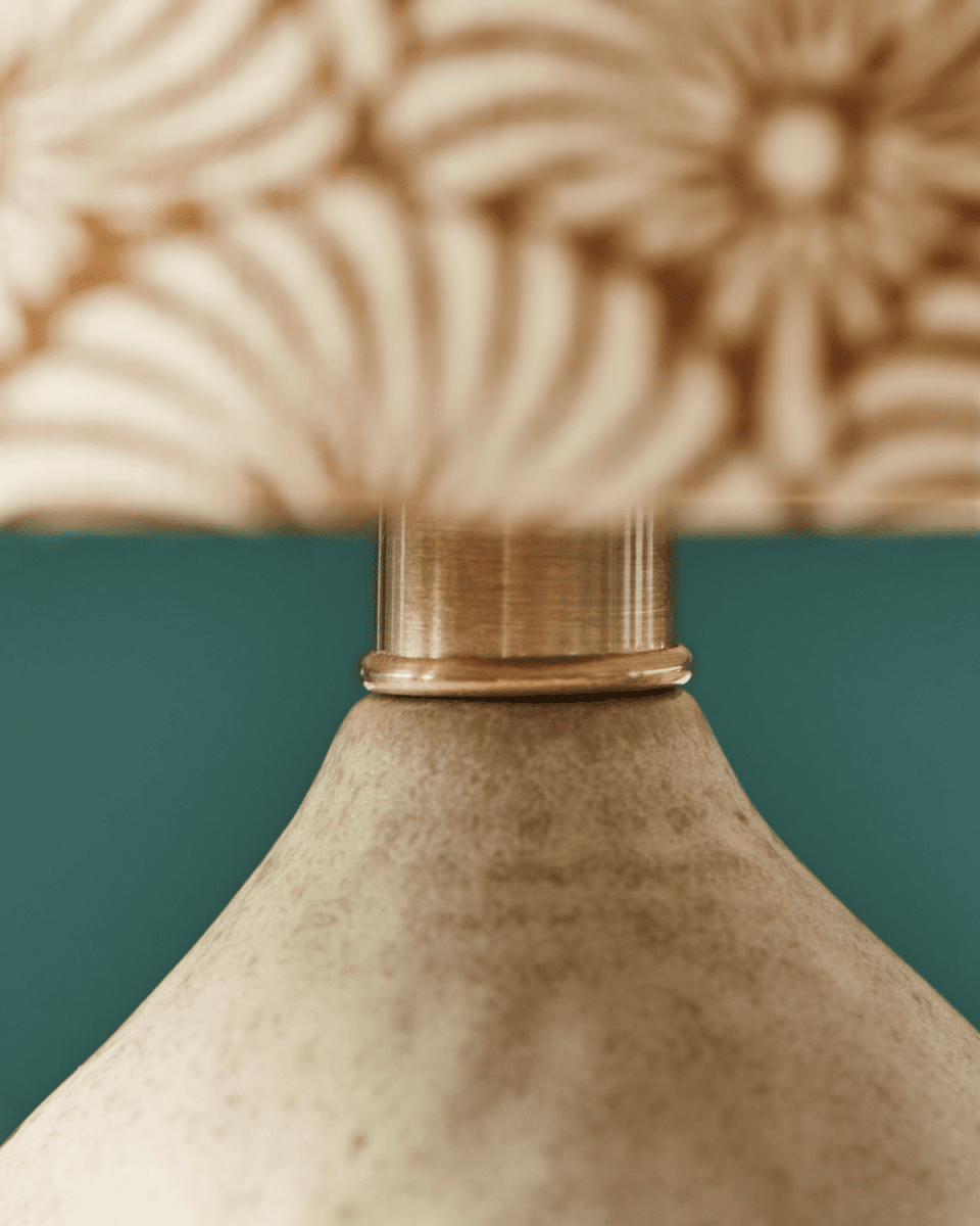 Flores 30cm Sable lampe de table De House Doctor - Il est doté d'une base en céramique couleur sable et d'un abat-jour en lin décoré de motifs de plumes de soleil sable et marron imprimés à la main, équilibrant magnifiquement une esthétique moderne et chaleureuse.