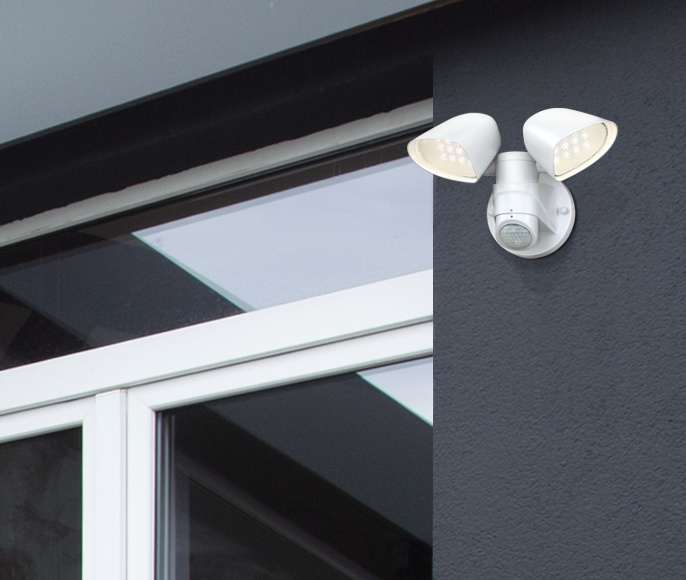 Two-Light Blanc lampe d’extérieur De Westinghouse - La lampe est équipée de deux têtes de lampe réglables qui peuvent être tournées de 135 degrés verticalement et de 160 degrés horizontalement pour couvrir une grande surface.