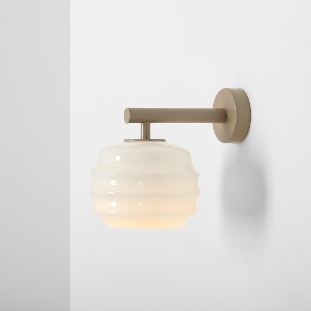 Puff 23cm Beige applique murale De Artera - Son abat-jour décoratif en verre opale blanc séduit par sa forme incurvée, conférant à la lampe une allure à la fois ludique et raffinée.