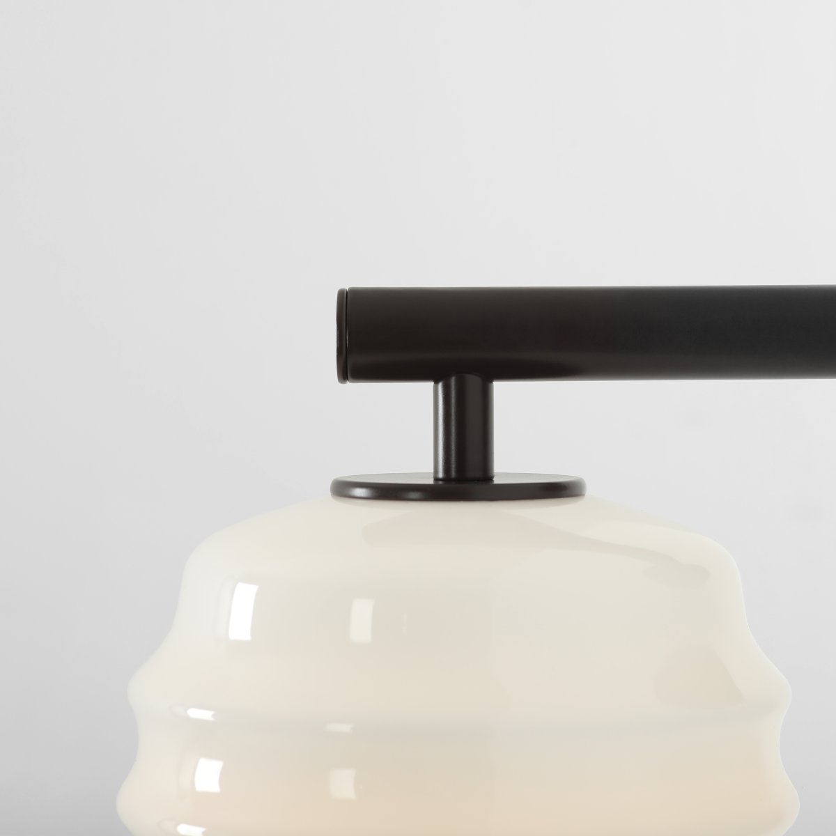 Puff 23cm brun foncé applique murale De Artera - Son abat-jour décoratif en verre opale blanc séduit par sa forme incurvée, conférant à la lampe une allure à la fois ludique et raffinée.