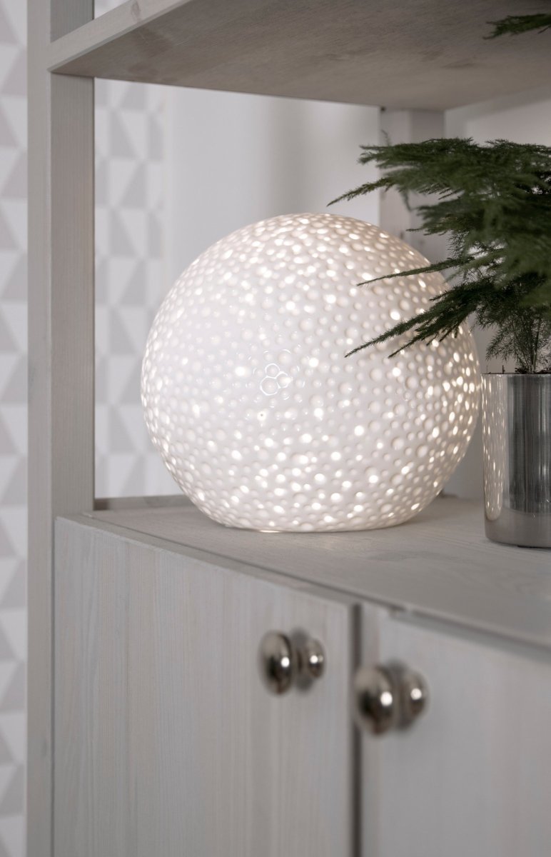 Moonlight 20cm Blanc lampe de table De Globen Lighting - La surface de cette lampe de table un peu plus moderne présente des trous perforés de différentes tailles ainsi que des cratères qui rappellent l'apparence des hommes.
