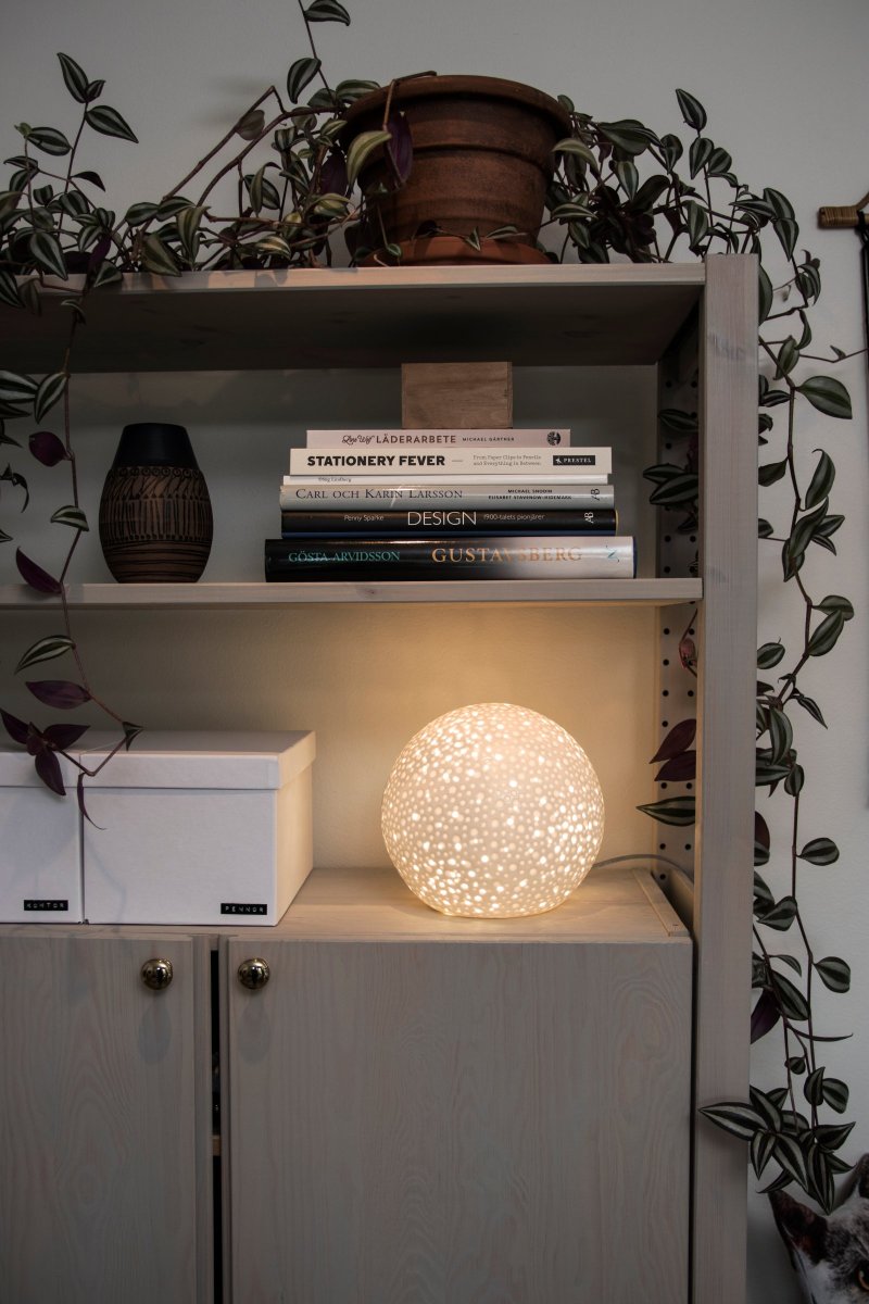 Moonlight 20cm Blanc lampe de table De Globen Lighting - La surface de cette lampe de table un peu plus moderne présente des trous perforés de différentes tailles ainsi que des cratères qui rappellent l'apparence des hommes.
