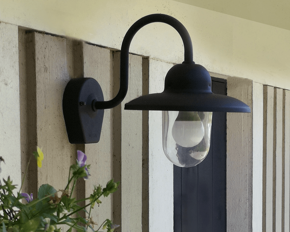 Nisse Noir lampe d’extérieur De Westal - Son abat-jour en verre transparent assure une diffusion optimale de la lumière et crée une ambiance chaleureuse aux entrées, façades et terrasses.