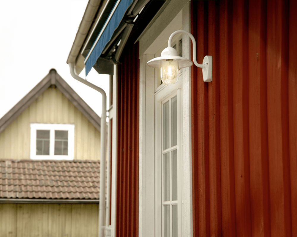 Nisse Blanc lampe d’extérieur De Westal - Son abat-jour en verre transparent assure une diffusion optimale de la lumière et crée une ambiance chaleureuse aux entrées, façades ou terrasses.