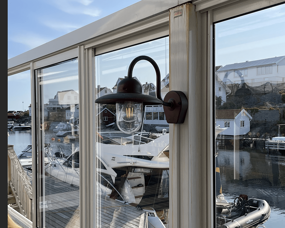 Nisse Cuivre oxydé lampe d’extérieur De Westal - Son abat-jour en verre transparent assure une diffusion optimale de la lumière et crée une ambiance chaleureuse aux entrées, sur les façades ou les terrasses.