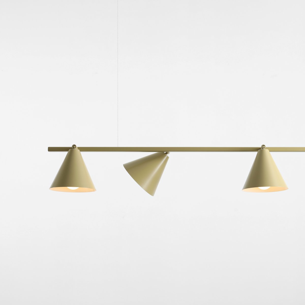 Form 120cm Pistache suspension De Artera - Sa forme allongée s'harmonise parfaitement avec ses quatre abat-jour coniques d'un doux vert pistache, conférant à la lumière un caractère à la fois moderne et décoratif.