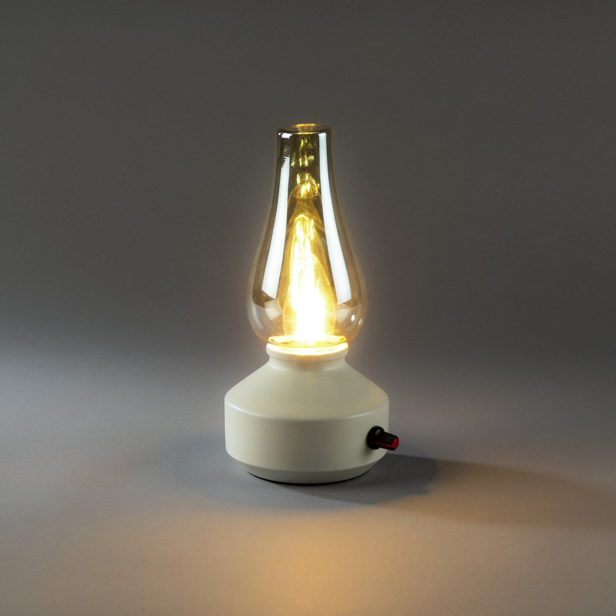 Lampe de table rechargeable 25cm Blanc portable De Konstsmide - Fabriquée en métal et en verre, elle est dotée d'un socle blanc et d'un variateur pratique permettant de régler facilement l'intensité de sa lumière blanche chaude et tamisée.