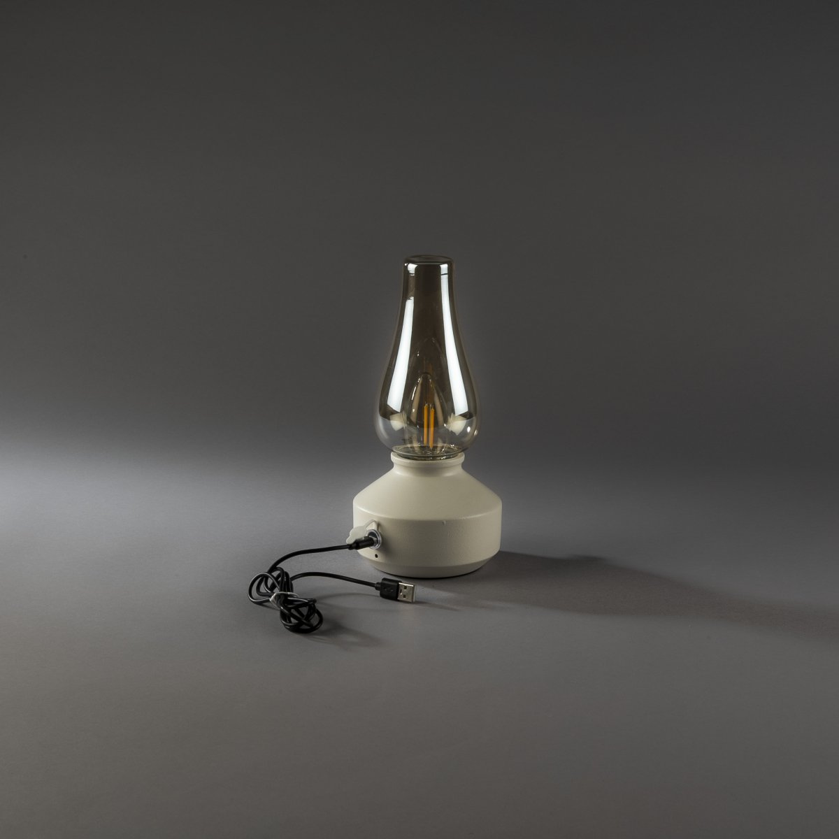 Lampe de table rechargeable 25cm Blanc portable De Konstsmide - Fabriquée en métal et en verre, elle est dotée d'un socle blanc et d'un variateur pratique permettant de régler facilement l'intensité de sa lumière blanche chaude et tamisée.