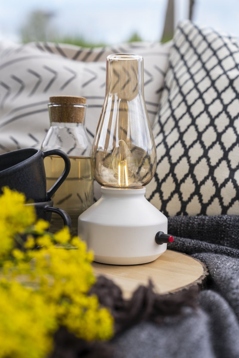 Lampe de table rechargeable 25cm Blanc portable De Konstsmide - Fabriquée en métal et en verre, elle est dotée d'un socle blanc et d'un variateur pratique permettant de régler facilement l'intensité de sa lumière blanche chaude et tamisée.