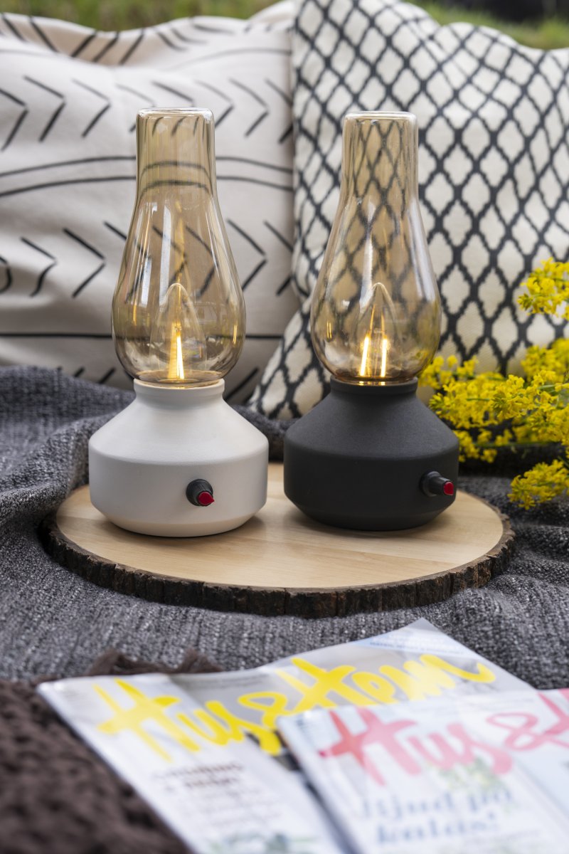 Lampe de table rechargeable 25cm Noir portable De Konstsmide - Fabriquée en métal et en verre, elle est dotée d'un socle noir et d'un variateur pratique permettant de régler facilement l'intensité de sa lumière blanche chaude et tamisée.