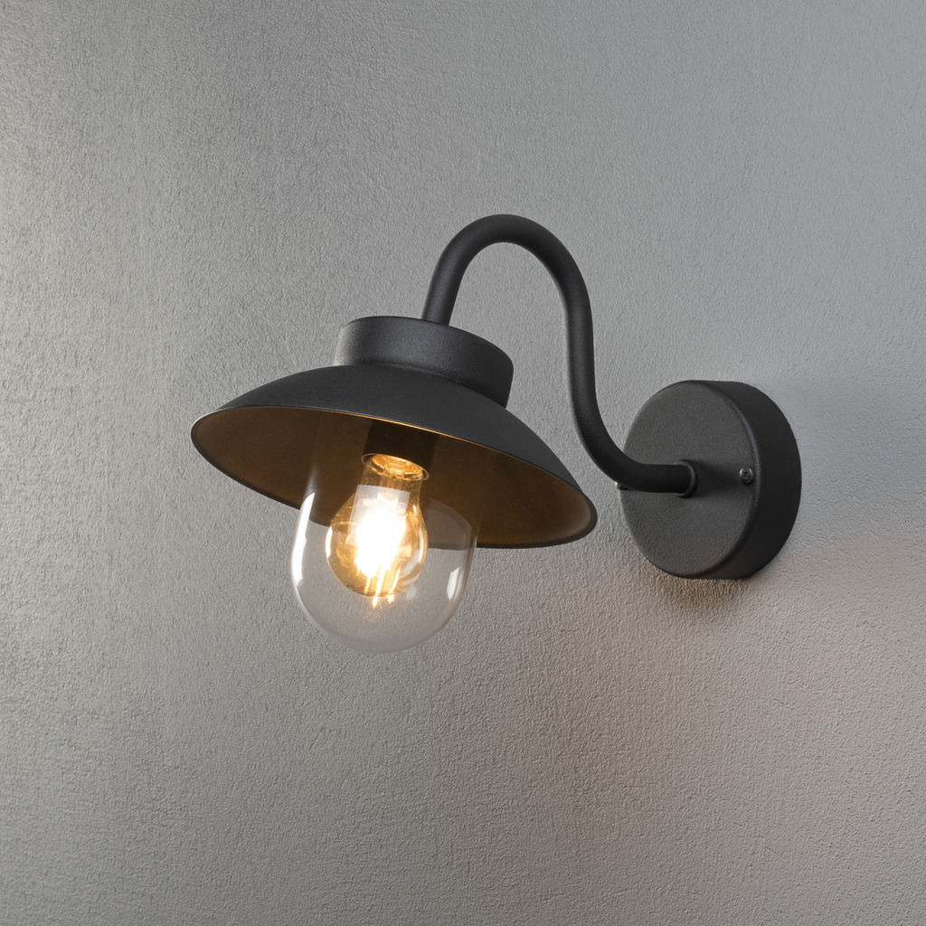 Vega Noir lampe d’extérieur De Konstsmide - L'abat-jour large et le dôme en verre transparent émettent une lumière agréable et dirigée, ce qui rend la lampe parfaite pour les entrées et les patios.