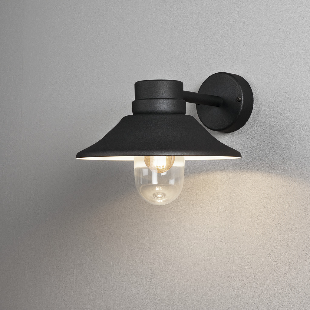 Vega Noir lampe d’extérieur De Konstsmide - L'abat-jour large et le dôme en verre transparent émettent une lumière agréable et dirigée, ce qui rend la lampe parfaite pour les entrées et les patios.